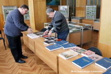 Сергей Борисович Борисов (слева) раскладывает свои печатные энциклопедические издания