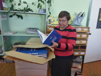 Вера Кугенева изучает экземпляры энциклопедии Нагайбакского района