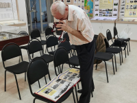 Александр Сухогузов фотографирует разворот альбома в Музее трудовой славы АО «Стронег» в городе Октябрьском (26 августа 2025 года). Фото: VK-страница ИБЭ АН РБ