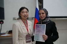 Руководитель направления академических партнёрств АНО «Интернет-энциклопедия „Рувики“» Людмила Цой (слева) вручает Благодарственное письмо Джамиле Товсултановой (15 апреля 2026 года). Фото: ЧГПУ