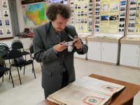 Равиль Фазылов фотографирует документ в Музее трудовой славы АО «Стронег» в городе Октябрьском (26 августа 2025 года). Фото: VK-страница ИБЭ АН РБ