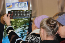 Победитель краеведческой викторины рассматривает приз — календарь с фото местной природы (23 октября 2013 года). Фото: «Работа и отдых»