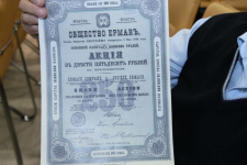Валерий Степанченко демонстрирует акцию АО «Ермак» 1898 года на презентации энциклопедического словаря-справочника «Ермак» (26 марта 2019 года)