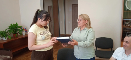 И. о. директора ИБЭ АН РБ Рания Хасанова (в центре) вручает Яне Зориной энциклопедию «Народы Башкортостана» (10 июля 2026 года)